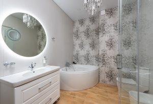 Creative design of bathroom with toilet bowl and small bath against mirror above washbasin and cabinet at home