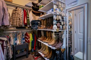 Assorted Clothes and Boots Inside a Closet Room